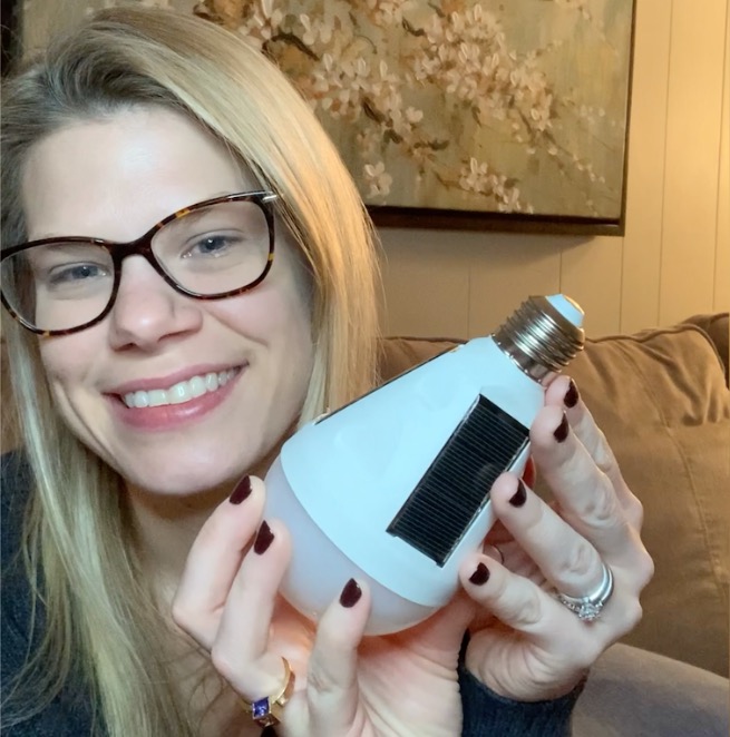 Woman smiling holding Eternalight bulb
